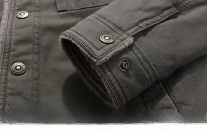 Dettaglio macro del polsino della giacca militare verde con fodera in pile grigio