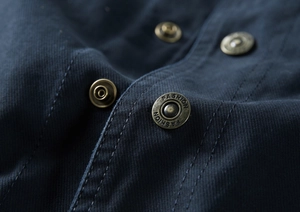 Détails des boutons FASHION en bronze et double couture sur la veste bleu marine