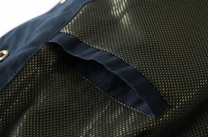 Vue macro du tissu sergé bleu marine avec doublure intérieure à pois dorés métalliques