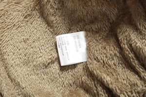 Detailed macro shot of 100% polyester brown jacket with warm fleece lining and care label