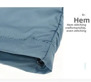 Close-up of adjustable drawstring hem with uniform stitching on blue outdoor jacket