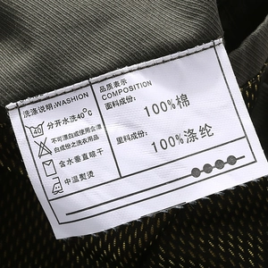 Macro shot of care label showing 100% cotton fabric and washing instructions for the jacket