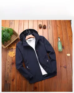 Flat lay of men's navy blue hooded windbreaker with waterproof fabric and arm badge detail