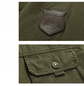 Detail showing army green cotton jacket with shield leather patch and metal button pocket