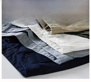 Détail de shorts en sergé de coton empilés en kaki, vert, blanc, gris et bleu