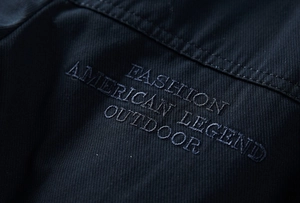 Close-up of fine embroidery on high-density twill fabric of a winter outdoor jacket