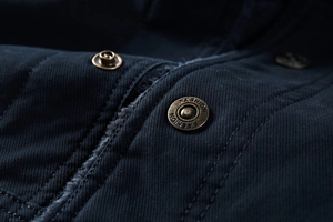 Macro detail of bronze fashion button and warm black plush fleece lining on the jacket