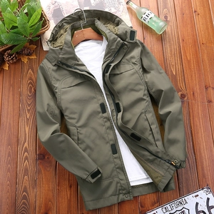 Men's army green outdoor waterproof hooded jacket with multiple pockets on dark wood floor
