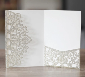 Macro shot of laser-cut mandala pattern on white and silver glitter wedding invitation