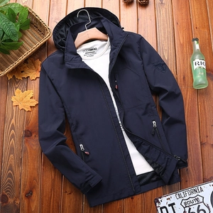 Men's navy hooded windbreaker jacket with zipper pockets on rustic wooden background