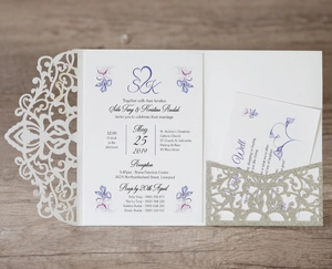 Detail of laser-cut wedding invitation with purple floral cards and gold glitter insert