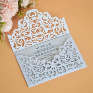 Close-up of laser-cut floral lace wedding invitation with elegant grey printed insert