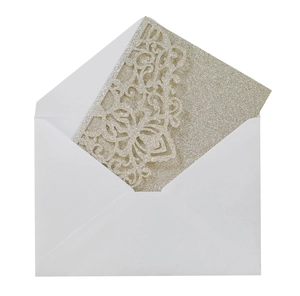 Detailed laser-cut scrollwork on gold glitter wedding invitation card with white envelope