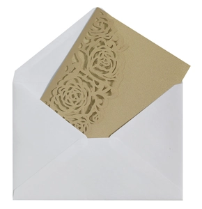 Détail de l'invitation dorée ajourée au laser avec motif rose et enveloppe blanche