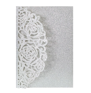 Detailed laser-cut silver glitter wedding invitation card with intricate rose patterns