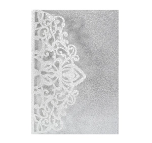 Macro detail of laser-cut silver glitter wedding invitation with floral lace patterns