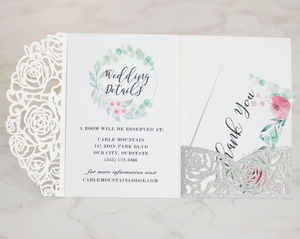 Detail of laser-cut rose wedding invitation set with silver glitter and thank you card
