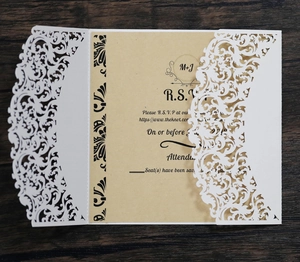 Detailed macro view of laser-cut lace wedding invitation with vintage RSVP kraft card insert