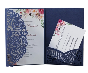 Détail d'invitation de mariage bleue découpée au laser avec motif rose et carte de réponse