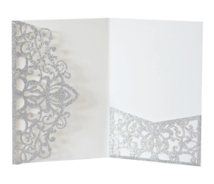Macro detail of silver glitter laser-cut invitation with intricate mandala lace pattern