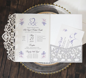 Detail of pink laser-cut lace wedding invitation with silver glitter card and floral patterns
