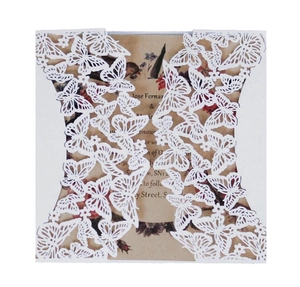 Détail d'invitation papillon blanche découpée au laser avec carte en papier kraft fleuri