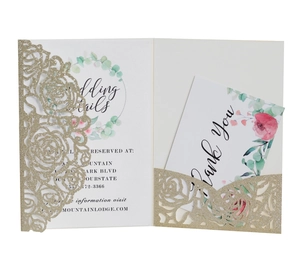 Detail of laser-cut floral wedding invitation with gold glitter texture and floral card