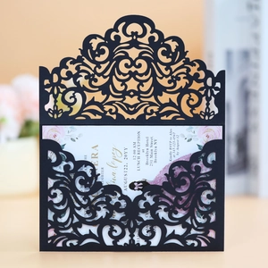 Macro view of laser-cut black invitation sleeve with intricate baroque patterns and floral insert
