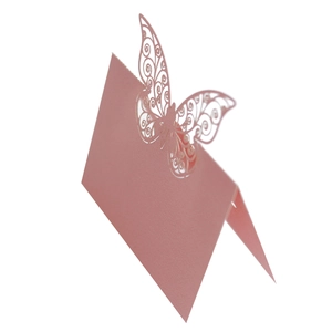 Detailed laser-cut hollow butterfly design on a pink tent-style wedding place card