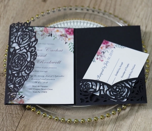Détail d'un faire-part de mariage noir découpé au laser avec motif de rose chic