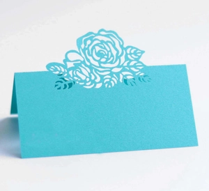 Detail of teal blue laser-cut rose flower design on a 3D wedding table place card