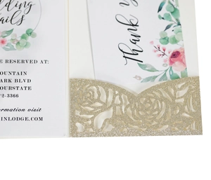 Detail of laser-cut rose champagne gold glitter wedding invitation with floral cards