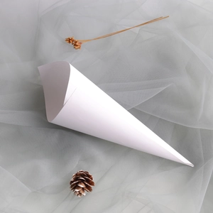 Top view of white kraft paper flower cones for weddings on soft gray tulle background