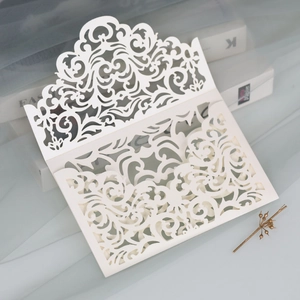 Detail view of pearlescent white laser-cut wedding invitation with elegant floral hollow pattern