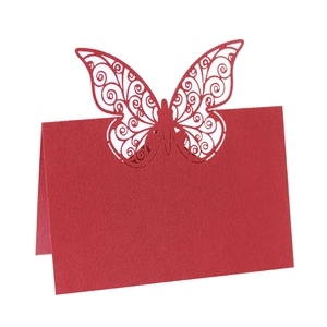 Detailed laser-cut butterfly design on a deep red pearlescent wedding place card