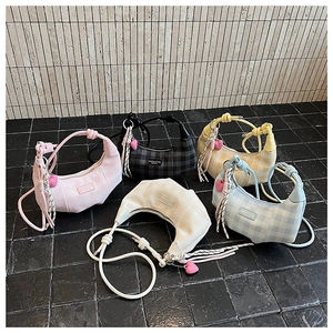 Group shot of colorful checkered crescent bags with heart charms and knotted shoulder straps