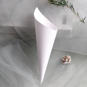 Macro view of white paper wedding confetti cone for petals and candy packaging