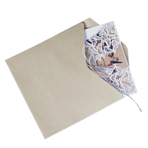 Détail du faire-part papillon découpé au laser avec enveloppe en papier kraft et ficelle