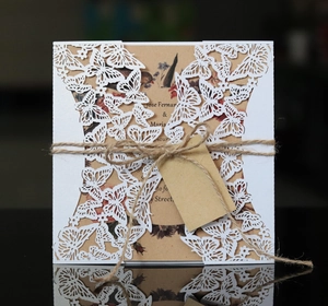 Détail de l'invitation papillon découpée au laser avec papier kraft, ficelle et motifs floraux