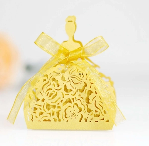 Detail of laser-cut paper gift box featuring an elegant yellow dress design and bow