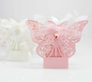 Macro view of laser-cut butterfly hollow candy box with pearl paper and soft pink ribbon