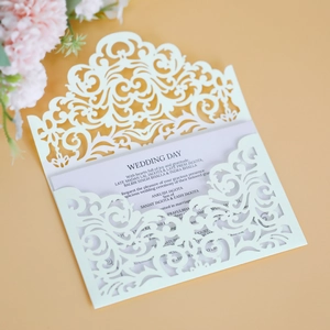 Elegant white laser cut wedding invitation card with sample text and floral decor