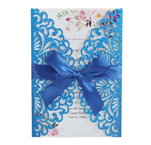 Invito di nozze laser-cut con nastro in raso blu e inserto floreale di grande dettaglio