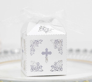 Macro detail of laser-cut cross and rose patterns on white pearlescent paper gift box