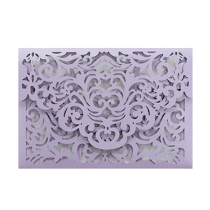 Detail of laser-cut lavender wedding invitation cover with elegant floral lace patterns