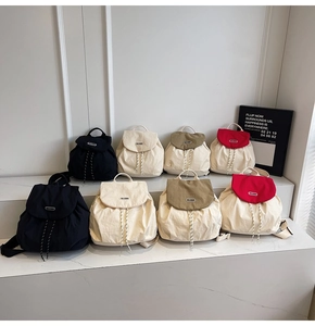 Detail view of large capacity nylon backpacks in four colors on marble stairs