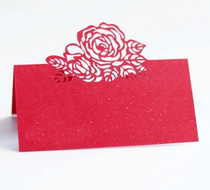 Macro detail of laser-cut red rose flower pattern on wedding place cards