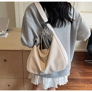 Detail of hobo bag with twill fabric texture and silver star pendant accessory