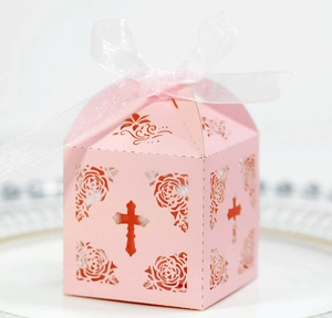 Detail of pink hollow gift box with laser-cut cross, roses, and white organza ribbon