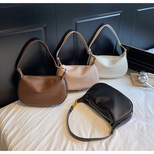 Detailed display of four leather crescent bags in brown, beige, white, and black colors